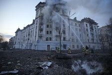 ウクライナの首都キーウでロシア軍による攻撃で発生した火災を消火する消防隊＝21日（AP＝共同）