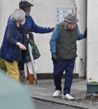 支援者に連れられ、日課の散歩に出かける袴田巌さん（右）＝25日午後、浜松市
