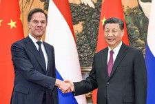 オランダのルッテ首相（左）と握手する中国の習近平国家主席＝27日、北京の人民大会堂（新華社＝共同）