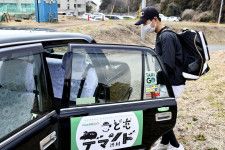 野球チームの練習を終え、「デマンドタクシー」に乗る伊能廉さん＝3月中旬、群馬県渋川市