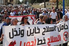 30日、イスラエル北部デールハンナで、「ガザでの戦闘をやめろ」と叫び行進するアラブ系市民ら（共同）
