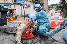 下水管の復旧のため、点検と清掃をする作業員＝3月29日、石川県珠洲市