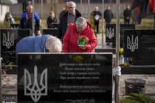 3月31日、ウクライナ・ブチャでロシア占領下に犠牲となった人々を追悼する式典が開かれ、戦死したウクライナ兵の墓に花を供える親族（AP＝共同）