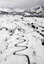 除雪された道路が雪原を縫うように浮かび上がる「立山黒部アルペンルート」＝2日午後1時5分、富山県立山町（共同通信社ヘリから）