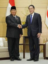 インドネシア次期大統領のプラボウォ国防相（左）と握手する岸田首相＝3日午前、首相官邸