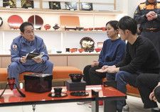 2月、地震で被災した石川県輪島市を訪れ、輪島塗の関係者らと話す岸田首相（左）