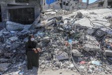 パレスチナ自治区ガザ南部ラファで、イスラエル軍によって攻撃を受けた建物の跡とパレスチナ人＝6日（ゲッティ＝共同）