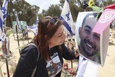 7日、イスラエル南部レイムで、息子のヤリン・エフラインさんの遺影を見つめる母オリーさん（共同）