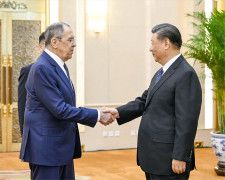 ロシアのラブロフ外相（左）と握手する中国の習近平国家主席＝9日、北京の人民大会堂（新華社＝共同）