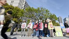 大阪市役所前で万博中止を訴える市民団体のメンバーら＝10日午後