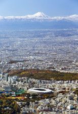 東京の上空から望む富士山。下は国立競技場＝2019年