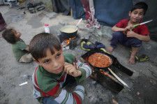 3日、パレスチナ自治区ガザで食事を待つ子ども（ゲッティ＝共同）