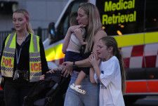 襲撃事件のあったショッピングモールから外に出た人たち＝13日、オーストラリア・シドニー（AP＝共同）