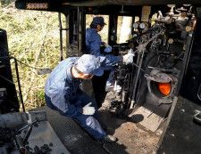 「SL人吉」の機関室で、石炭を投入する「火室」をうかがう機関助士＝2024年3月7日、熊本市（超広角レンズで撮影）