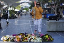 事件が起きたオーストラリア・シドニーのショッピングモール近くに花を手向けに訪れた女性＝14日（AP＝共同）