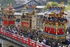 岐阜県高山市で「春の高山祭」が始まり、市中心部の橋を渡る屋台＝14日午前