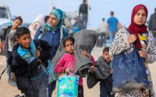 ガザ地区北部の自宅に戻ろうとするパレスチナ人避難民ら＝15日、ガザ中部（ロイター＝共同）