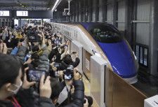 北陸新幹線の金沢―敦賀間が延伸開業し、JR福井駅に到着した東京行きの一番列車を出迎える大勢の人たち＝3月16日、福井市
