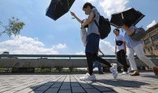 昨年7月、厳しい暑さの中、京都市内を日傘を差して歩く人たち