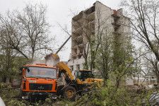 ロシア軍のミサイル攻撃を受けた建物と重機による復旧作業＝17日、ウクライナ北部チェルニヒウ（共同）