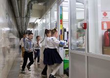ウクライナ東部ハリコフの地下鉄駅構内につくられた教室の廊下を走る子どもたち。教室や廊下には窓がない＝15日（共同）
