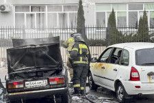 3月、ロシア・ベルゴロドで、ウクライナ側の攻撃によって破壊された車両近くで作業する人たち（ベルゴロド州知事の通信アプリから・AP＝共同）