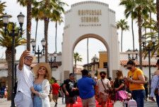 米ロサンゼルスの「ユニバーサル・スタジオ・ハリウッド」で自撮りする訪問客＝2021年6月（ロイター＝共同）