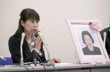 母親の津田広子さんの遺影を前に記者会見する原告の服部昌子さん＝22日午後、北九州市