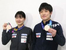 卓球のシングルスのワールドカップから帰国し、メダルを見せる張本智和（右）と妹美和＝22日、成田空港