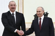 クレムリンでの会談で握手を交わすロシアのプーチン大統領（右）とアゼルバイジャンのアリエフ大統領＝22日、モスクワ（AP＝共同）