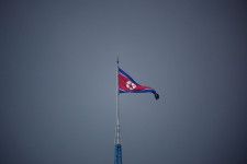 南北軍事境界線の北側にある北朝鮮の「宣伝村」に掲げられた国旗。韓国側から撮影された＝2022年7月（ロイター＝共同）