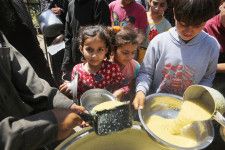 ガザ地区中部デールバラハで、食料配給の列に並ぶ子どもたち＝19日（ゲッティ＝共同）
