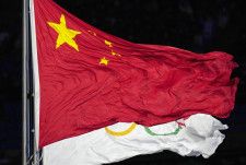 北京冬季五輪開会式で、たなびく中国国旗と五輪旗＝2022年2月（AP＝共同）