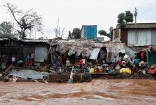 あふれた川の水で壊れた家屋＝25日、ナイロビ（ロイター＝共同）