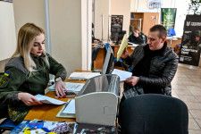 ウクライナ南部ザポロジエ州で警備隊への入隊を希望し書類に記入する男性（右）＝2023年2月（ゲッティ＝共同）