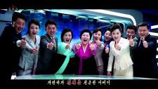 北朝鮮の朝鮮中央テレビが17日放映した「親しいオボイ」の一場面で、同僚と笑顔で親指を立てる看板アナウンサーの李春熙氏（左から5人目）（共同）