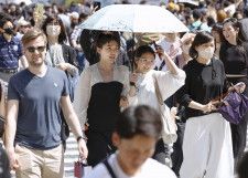 東京・渋谷のスクランブル交差点を日傘を差して歩く人たち＝28日午後