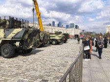 モスクワの戦勝記念公園で、ウクライナ側から奪った戦闘車両を見物する市民＝25日（共同）