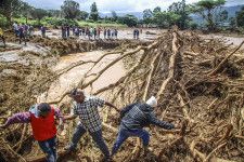 ダム決壊後の地区で水害に対処する人々＝29日、ケニア中部（AP＝共同）