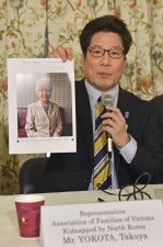 記者会見で横田早紀江さんの写真を見せる拉致被害者家族会代表の拓也さん＝4月30日、ワシントン（共同）