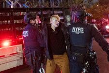 4月30日、ニューヨーク市立大でデモ参加者を拘束する警察官＝ニューヨーク（ゲッティ＝共同）