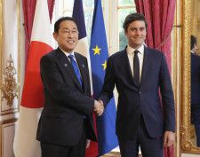 フランスのアタル首相（右）と握手する岸田首相＝1日、パリの首相府（共同）