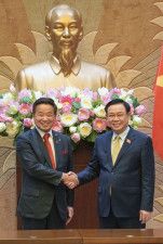 ベトナムの首都ハノイで日本企業関係者と握手するブオン・ディン・フエ氏（右）＝3月（共同）