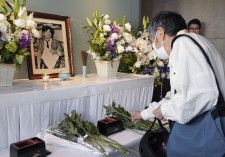 朝日新聞阪神支局に設けられた小尻知博記者の祭壇に、花を手向ける地元住民＝3日午前、兵庫県西宮市