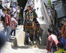 三重県桑名市の多度大社で行われた、地元の青年が馬に乗って坂を駆け上がる「上げ馬神事」。高さ2メートルの土壁を撤去し、勾配を緩めるなど今年から大幅に様式を変更した＝4日午後