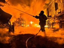 ウクライナ東部ハリコフのロシア軍による無人機攻撃を受けた現場で消火作業に当たる消防士＝4日（ロイター＝共同）