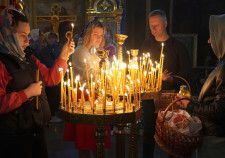 5日、ウクライナ・キーウの聖ミハイル黄金ドーム修道院で、ろうそくをともし祈る市民ら（共同）