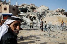 5日、パレスチナ自治区ガザ南部ラファで、イスラエルの攻撃を受けた家屋付近にたたずむ男性（ロイター＝共同）