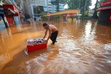 南部ポルトアレグレで洪水の中、野菜や果物を運ぶ人＝5日（ゲッティ＝共同）