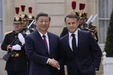6日、フランス・パリで握手を交わすマクロン大統領（右）と中国の習近平国家主席（AP＝共同）